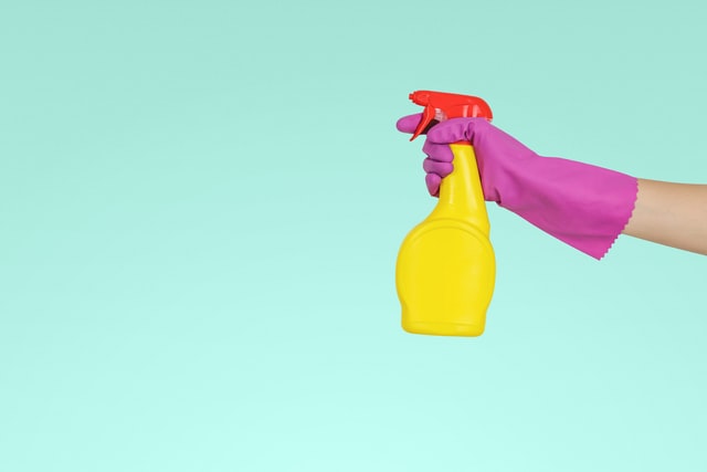 Person holding a cleaning product.
